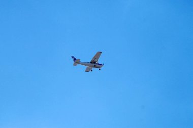 Mavi gökyüzünde küçük bir planör uçar, yakın planda..