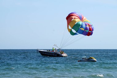 Varna, Bulgaristan - 20 Eylül 2021: deniz paraşütü, turistler denizdeki bir tekneden paraşütle atlıyor
