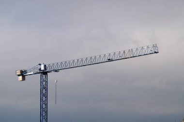Bulutlu gökyüzüne karşı uzaktan kontrollü inşaat vinci.