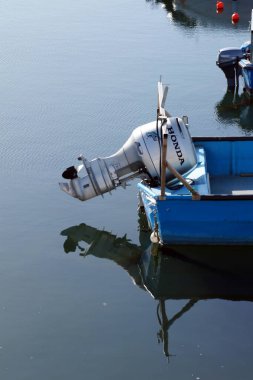 Varna, Bulgaristan - 20 Nisan 2025: bir deniz teknesine bağlı yükseltilmiş bir Honda motoru suya yansıyor. Yakın plan..