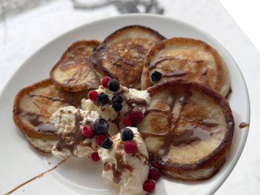 Kızarmış krep ve dondurmayla birlikte beyaz tabakta taze böğürtlen ve çikolata sosu..