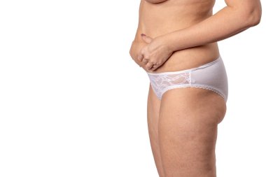 Koca göbekli bir kadın karnını tutuyor.