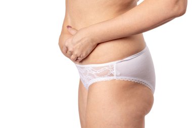 Koca göbekli bir kadın karnını tutuyor.