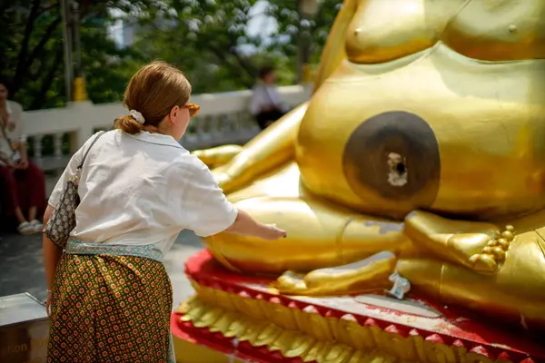 pattaya, Tayland. 03.18.2025. Büyük Buda tapınağı. Bir kız bozuk parayla ritüel yapar.