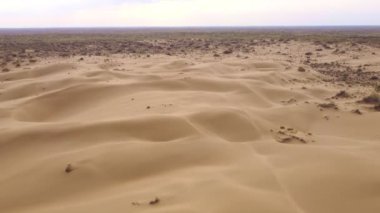 Flight over the dunes in the desert. beautiful top view of the Kyzyl Kum desert in kazakhstan at sunrise. Oriental landscapes of Central Asia, a lifeless arid area without water
