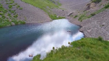 Aksujabaglinsky rezervindeki pitoresk göl manzarası, yazın dağların arasında göl, Goach 'ta yüksek Moraine küçük gölü, güzel zümrüt suyu.