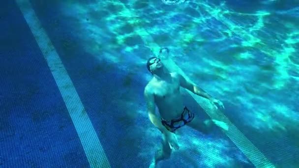Ein Mann Boden Eines Blauen Pools Gibt Runde Blasen Aus — Stockvideo