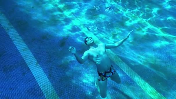 Een Man Bodem Van Een Blauw Zwembad Laat Ronde Bellen — Stockvideo
