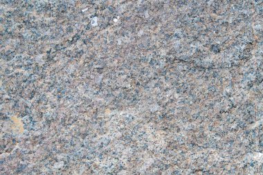 Fotoğraftaki granüler granit dokusu ince taneli bir hafif taşı gösteriyor. Taşın düzgün bir tahıl dağılımı var, pürüzsüz ama desenli bir görünüm yaratıyor, gölgelerle.