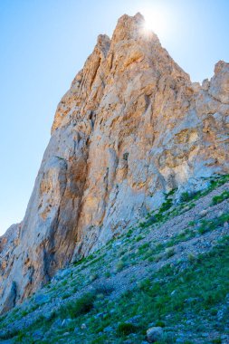 Güneş ışınları kayalık tepenin üzerinden kırılarak ışık ve taştan oluşan görkemli bir kontrastı yaratır.