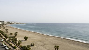 Beach with umbrellas and chairs in cloudy weather on the beach