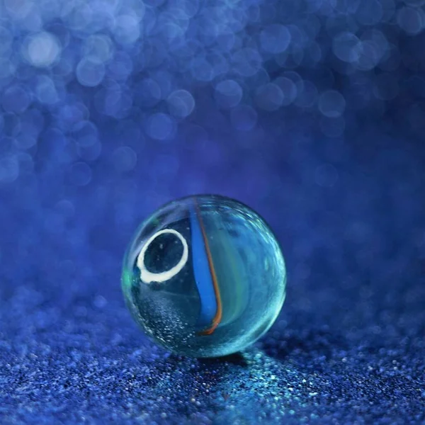 Bola Vidrio Sobre Mesa Azul Brillante Con Fondo Borroso Burbujas — Foto de Stock