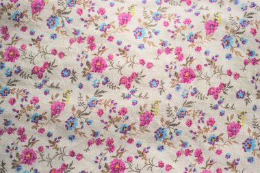 Çiçek desenli şirin keten kumaş, bej kumaşta pembe ve mavi çiçekler..