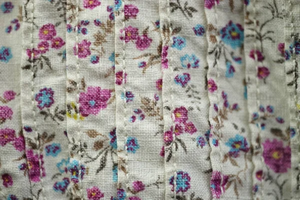 Thick linen fabric with a cute floral pattern, pink and blue flowers on a beige material.