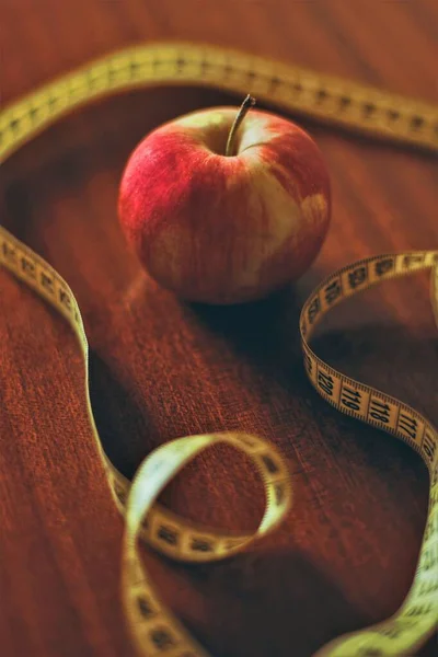 Czerwone Jabłko Żółta Taśma Pomiarowa Brązowym Drewnianym Stole — Zdjęcie stockowe