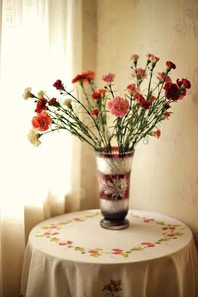 窓のそばの部屋にリネンのテーブルクロスを持つテーブルの上にアスターの花の花束 — ストック写真