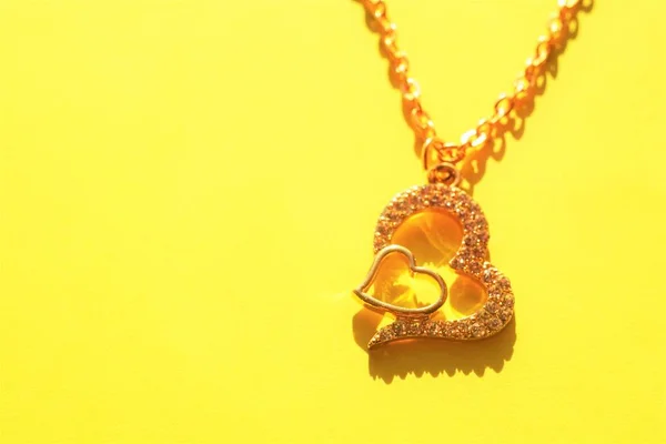 Золотий Ланцюг Кулоном Вигляді Двох Сердець Камені Сонячно Жовтому Столі — стокове фото