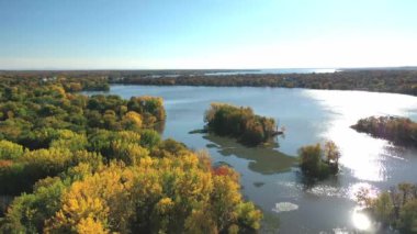 Hava aracı videosu Laval-Ouest 'i çevreleyen sonbaharın renkli ağaçlarını Mille Iles nehrinin üzerinde gösteriyor.