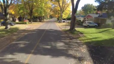 Şehrin bir caddesinde, renkli olgun ağaçlarla çevrili 80 'lerin özelliklerini gösteren bir video.