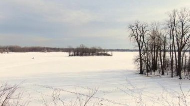 Düşük açıyla uçmak ve St-Eustache 'deki donmuş nehre doğru ilerlemek, insanlara buz balıkçılığını göstermek