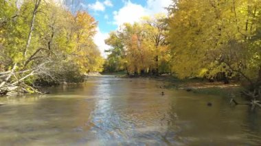 Çok yavaş uçuyor küçük nehrin üstünde, renkli ağaçların ortasında St-Eustache 'nin renkleri ile.