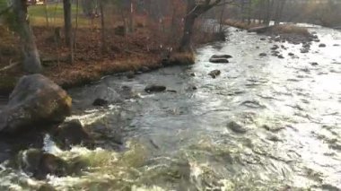Drone görüntüsü yavaşça geriye, ağaçların arasından Brownsburgh-Chatham nehrinin üzerinden geçiyor.