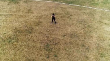 Koşucu koşudan önce çömelme egzersizi yapıyor