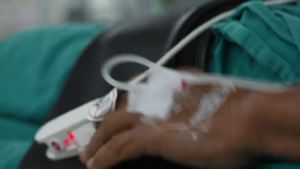 Pacjent Parkinsonem Drżącą Ręką Leżącą Łóżku Kroplówką Toksymetrią Pulsu — Wideo stockowe