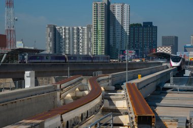 Bangkok, Tayland-25 Kasım 2023: Pembe Hat elektrikli treni, son istasyon Pak Kret istasyonunda, mor elektrik treninin karşısında ilerliyor..