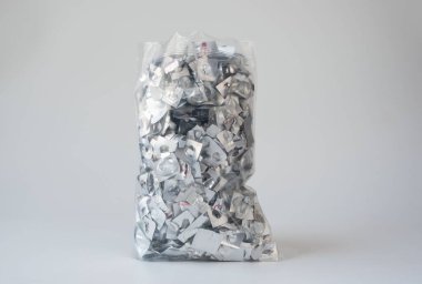 Boş alüminyum kabarcık artıklarıyla dolu temiz bir plastik torba, ilaç atıkları ve çevresel geri dönüşüm endişelerini vurguluyor. Görüntü tıbbi tüketimi, sürdürülebilirliği ve atık yönetimini vurguluyor.