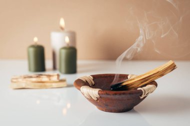 Palo santo yakma çubuğu ve arka planda kopyalanmış mumlar