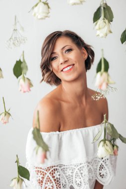 Beautiful woman with bob haircut posing in studio with beautiful bouquet clipart