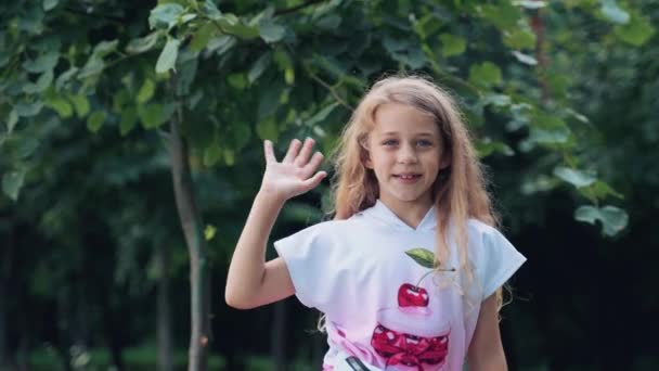 活泼快乐的孩子挥挥手 公园里一个小女孩的画像 人类的情感用手指的图形和手势 — 图库视频影像