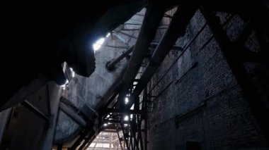 Terk edilmiş eski bir fabrikanın korkunç karanlık kalıntıları. Tuğla duvar, paslı borular ve kömür santralinin metal yapıları..