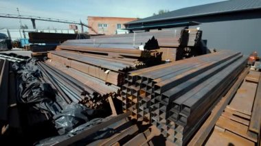 Büyük endüstriyel metal ürünleri deposu, açık havada borular. Metal çelik açı, satılık kanallar..
