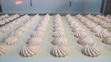 Şekerleme fabrikasındaki şekerleme suflesiyle taşıma bandı. Sıralama için bitmiş ürünlerin satırları.