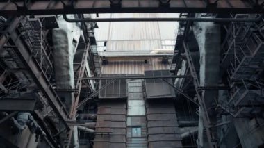 Büyük paslı metal boruları ve yapıları olan terk edilmiş bir fabrikanın kıyamet sonrası görüntüsü. Yok edilmiş kömür santrali. Eski sanayi bölgesi.