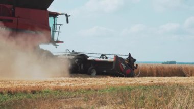 VINNYTSIA, UKRAINE - 19 Temmuz 2020: Sarı buğdaylı bir tarlada hasat işçisi. Çim biçme makinesini hasat için hazırlıyorum. Tekerleklerin tozu..