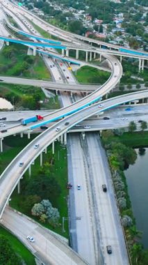 Otoyol 95 ve Florida Eyaleti 112 'nin kesiştiği yerin hava görüntüsü. Arabalar ve yol işaretleriyle çok katlı bir kavşak. Dikey video.