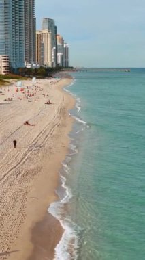 Sunny Isles Beach Florida 'daki İHA videosu. Haulover Çıplaklar Plajı 'ndan otelin havadan görünüşü. Atlantik Okyanusu kıyısında. Dikey video.