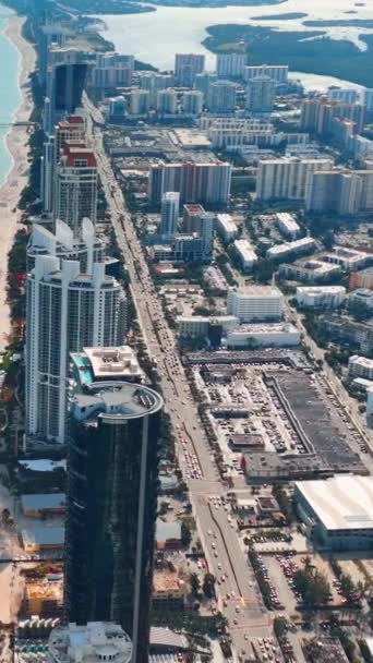マイアミサニー諸島ビーチは高級ホテルと砂浜のフロントを備えています 車やレクリエーションインフラを備えたコリンズ アベニューの空中ビュー バーティカルビデオ — ストック動画