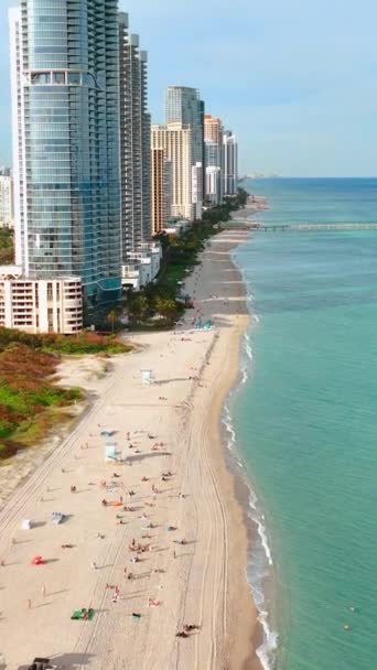 从空中俯瞰美国佛罗里达州迈阿密阳光岛海滩 Sandy Haulover Nude海滩高耸的酒店在海岸 垂直录像 — 图库视频影像