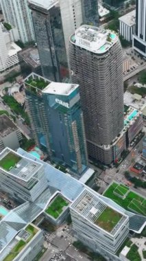 Miami, Florida, ABD - 05 Ocak 2024: Gökdelenleri ve cam binaları olan Brickell şehir merkezinin hava manzarası. Yüksek binaların çatıları var. Dikey video.