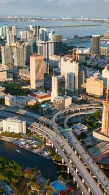 Miami, Florida, ABD - 05 Ocak 2024 Miami şehir merkezinde, turuncu gün batımında. Gün batımında şehir merkezindeki sahil Bay City 'nin hava manzarası. Dikey video.