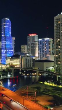 Miami, Florida, ABD - 05 Ocak 2024: Geceleri Miami 'nin havadan görünüşü. Parlayan sokak lambaları, trafik ve gökdelenleri olan şehir merkezi. Dikey video.