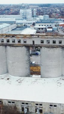 Büyük kimya fabrikası. Yeni bir modern fabrikanın arka planına karşı eski bir binanın havadan görünüşü. Dikey video.