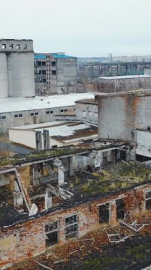 Şehrin eski harabe binalarının manzarası. Terk edilmiş fabrika manzarası. Dikey video.