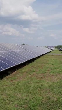 Yenilenebilir elektrik üretimi için güneş enerjisi panelleri olan yeşil alan. Dikey video.