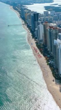Atlantik Okyanusu 'nun kıyı şeridi. Otelleri ve kumsalı var. Miami plajının havadan görüntüsü. Dikey video.