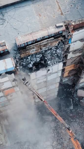 機械による古い多階建ての建物の破壊 建設現場の掘削機の作業 破壊からの塵の雲 バーティカルビデオ — ストック動画
